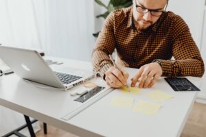 a man writing on the sticky notes